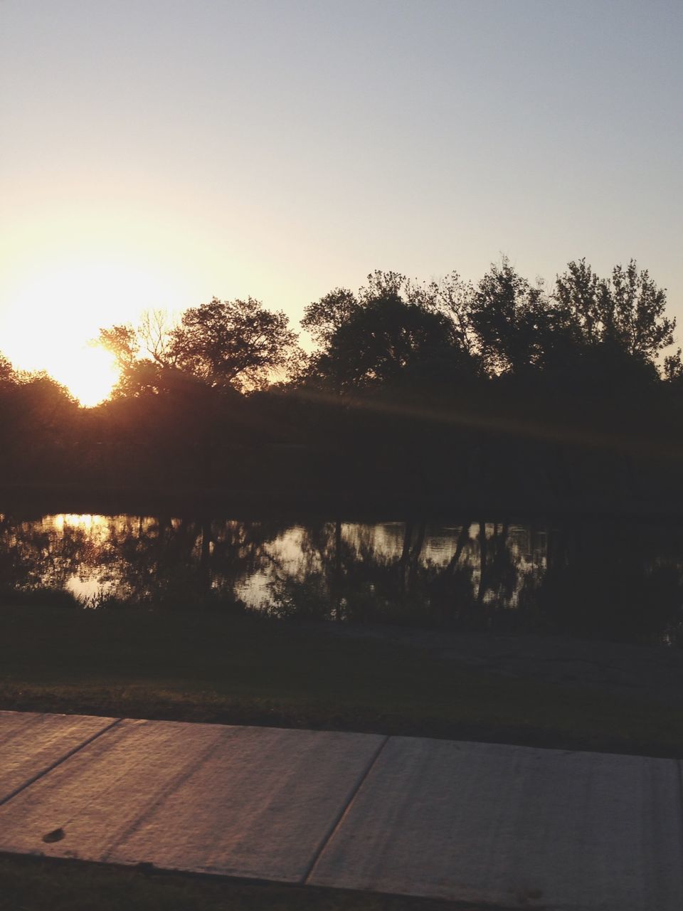 sunset, tree, water, tranquil scene, lake, tranquility, reflection, clear sky, sun, scenics, silhouette, beauty in nature, nature, sunlight, river, sky, idyllic, copy space, outdoors, lakeshore