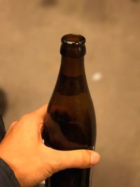 Close-up of hand holding beer bottle