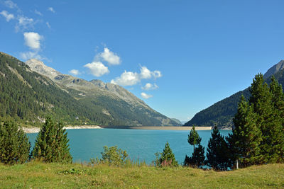 Scenic view of lake and mountains against blue sky