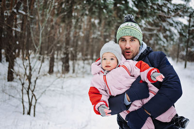 Outdoor family activities for happy winter holidays. happy father playing with little baby toddler