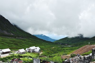Scenic view of houses and mountains against sky