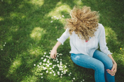 Rear view of girl sitting on grass