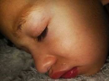 Close-up of baby sleeping on bed