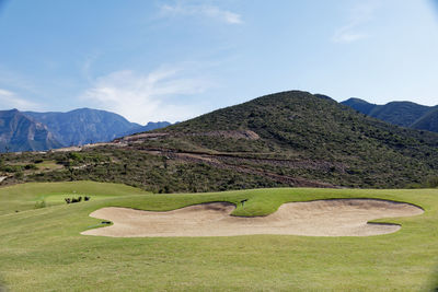 Scenic view of golf course against sky