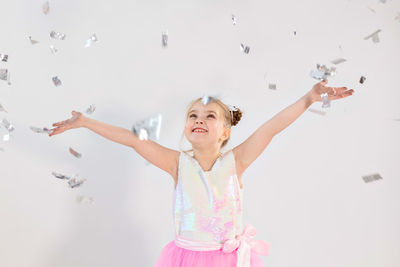 Portrait of happy girl with arms raised