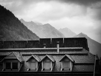 High section of house and buildings against sky