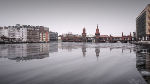 View of river with buildings against clear sky