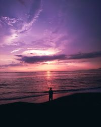 Silhouette of man fishing at sunset