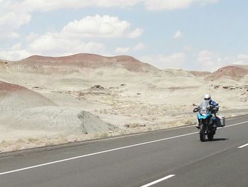 Scenic view of mountain road against cloudy sky