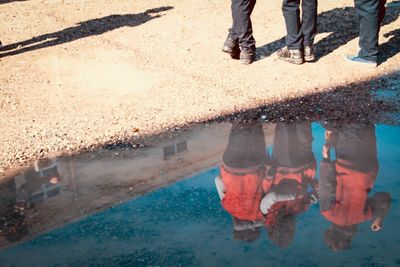 Low section of people standing by swimming pool