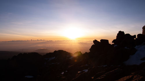 Scenic view of silhouette mountains against sky during sunset