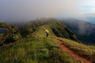 Woman walking on mountain against sky