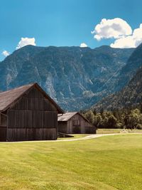 Built structure on field by mountains against sky