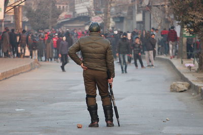 Rear view of people walking on street in city