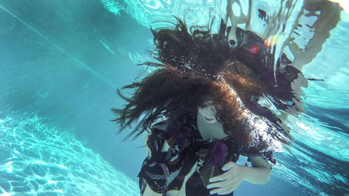 Woman swimming underwater in pool