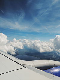 Airplane flying over clouds against blue sky