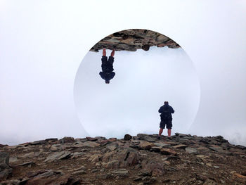 Low angle view of man standing on rock formation