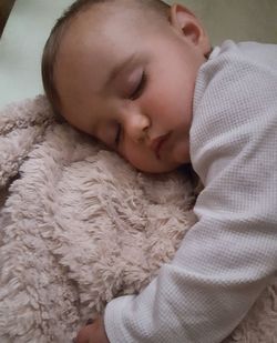 Close-up of baby sleeping on rug