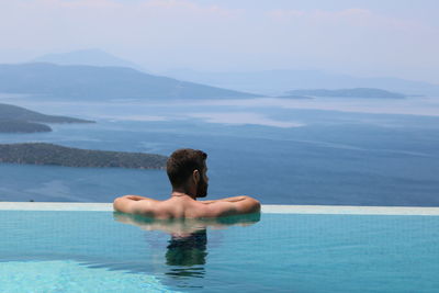 Rear view of man swimming in pool