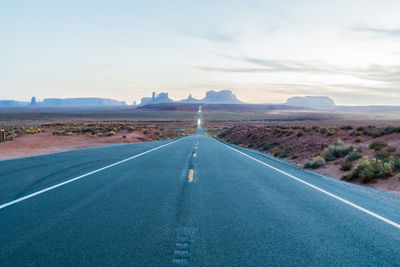 Empty road along landscape against sky