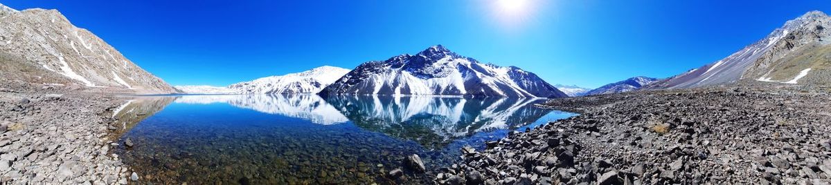 Panoramic view of snowcapped mountains against clear blue sky