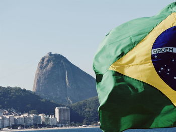 Close-up of waving flag with buildings in background