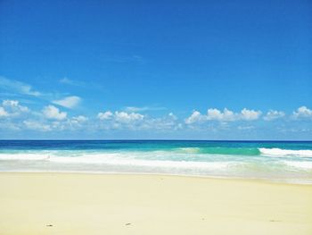 Scenic view of beach against blue sky