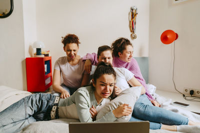 Female friends watching scary movie together at home