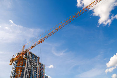 Low angle view of crane against sky