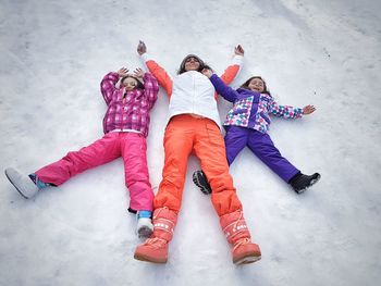 High angle view of girl lying on snow