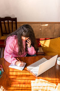 High angle view of woman sitting on table