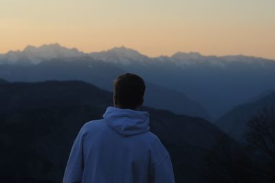 Rear view of man on mountain during sunset