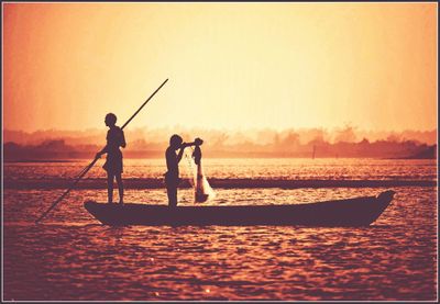 Silhouette of boat in sea at sunset