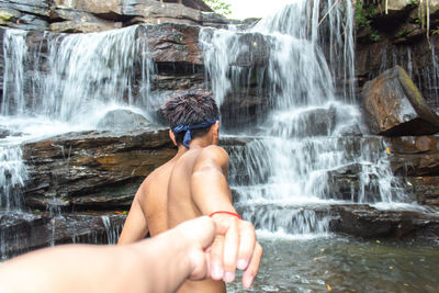 Man looking at waterfall