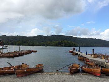 Sailboats moored on lake against sky