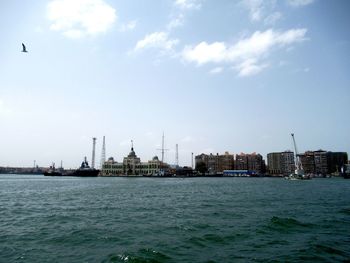 Scenic view of sea by buildings against sky