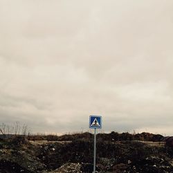 Low angle view of road sign against sky