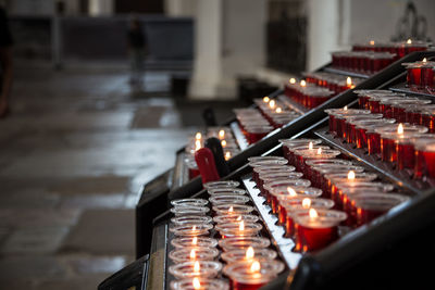 Candles in the church. votive prayer candles inside a catholic church on a candle rack.