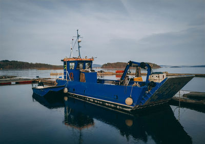 Fishing boat moored on sea against sky