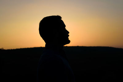 Silhouette man against clear sky during sunset