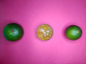 Directly above shot of fruits against pink background