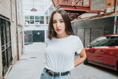 Portrait of young woman standing in city