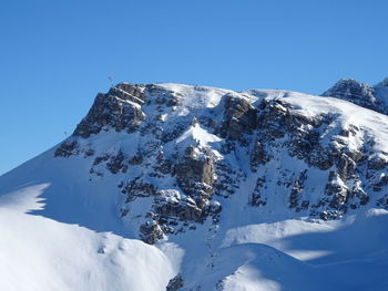 Snow covered mountain against blue sky