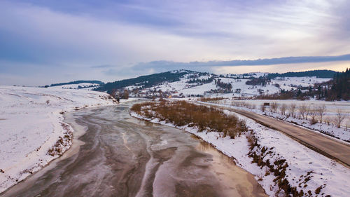 Snow covered land against sky