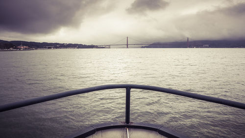 View of bridge over sea against cloudy sky