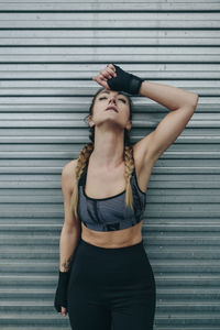 Young woman standing against wall