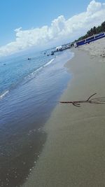 Scenic view of beach against cloudy sky