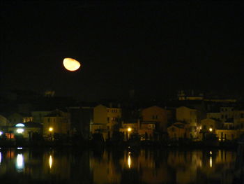 Illuminated city against sky at night