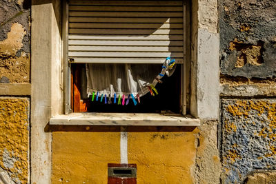 Low angle view of window hanging on wall of building