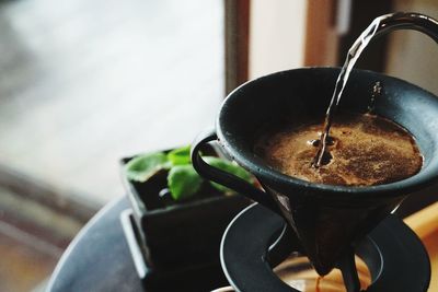 Close-up of drink pouring in coffee cup